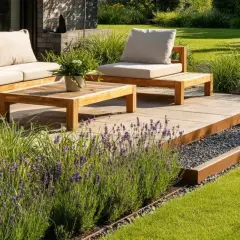 Moderne terrassenumrandung ideen mit Cortenstahl und Kies. Holzmöbel und Lavendel schaffen eine einladende Atmosphäre.