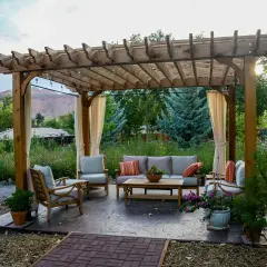 Gemütliche Lounge unter einem selbstgebauten Terrassendach mit Lichterkette. Perfekt für entspannte Abende im Garten.