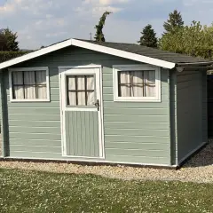 Frisch gestrichenes Gartenhaus in Mintgrün, mit weißen Fensterrahmen und Tür. Ein schöner Blickfang im sonnigen Garten.