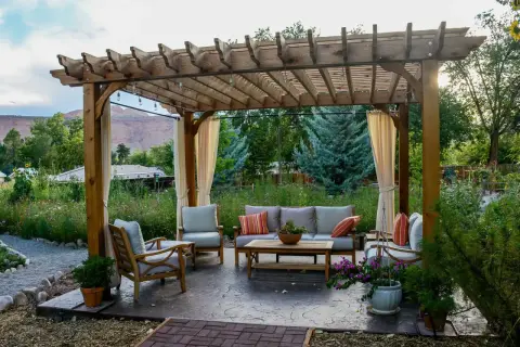 Gemütliche Lounge unter einem selbstgebauten Terrassendach mit Lichterkette. Perfekt für entspannte Abende im Garten.