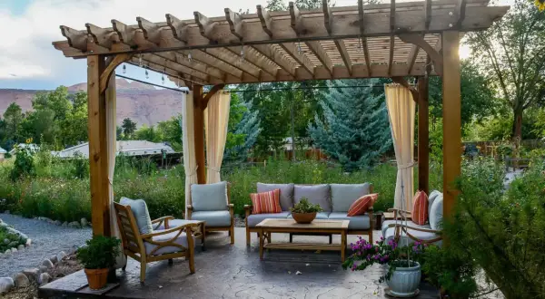 Gemütliche Lounge unter einem selbstgebauten Terrassendach mit Lichterkette. Perfekt für entspannte Abende im Garten.