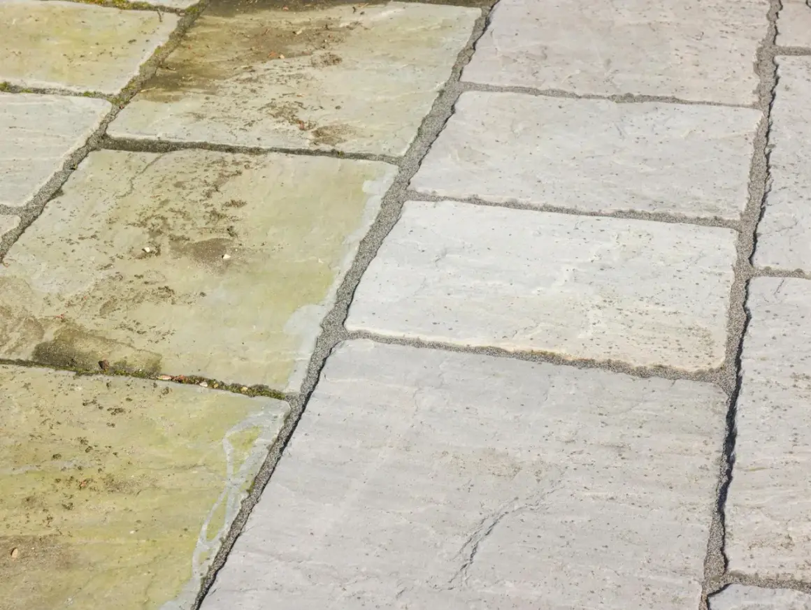 Terrassenplatten reinigen: Eine Hälfte der Platten ist sauber und hellgrau, die andere ist schmutzig und grünlich.