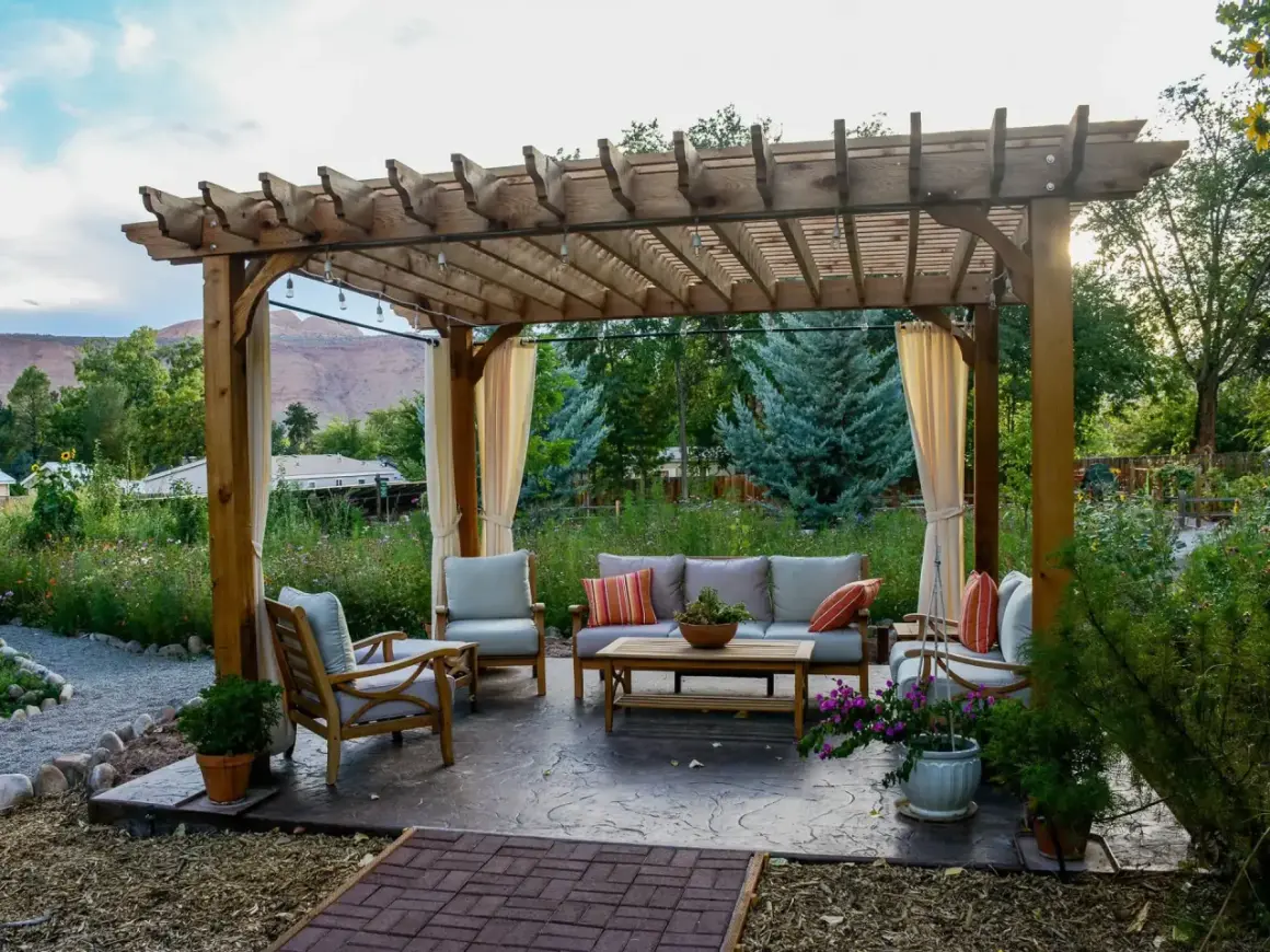 Gemütliche Lounge unter einem selbstgebauten Terrassendach mit Lichterkette. Perfekt für entspannte Abende im Garten.