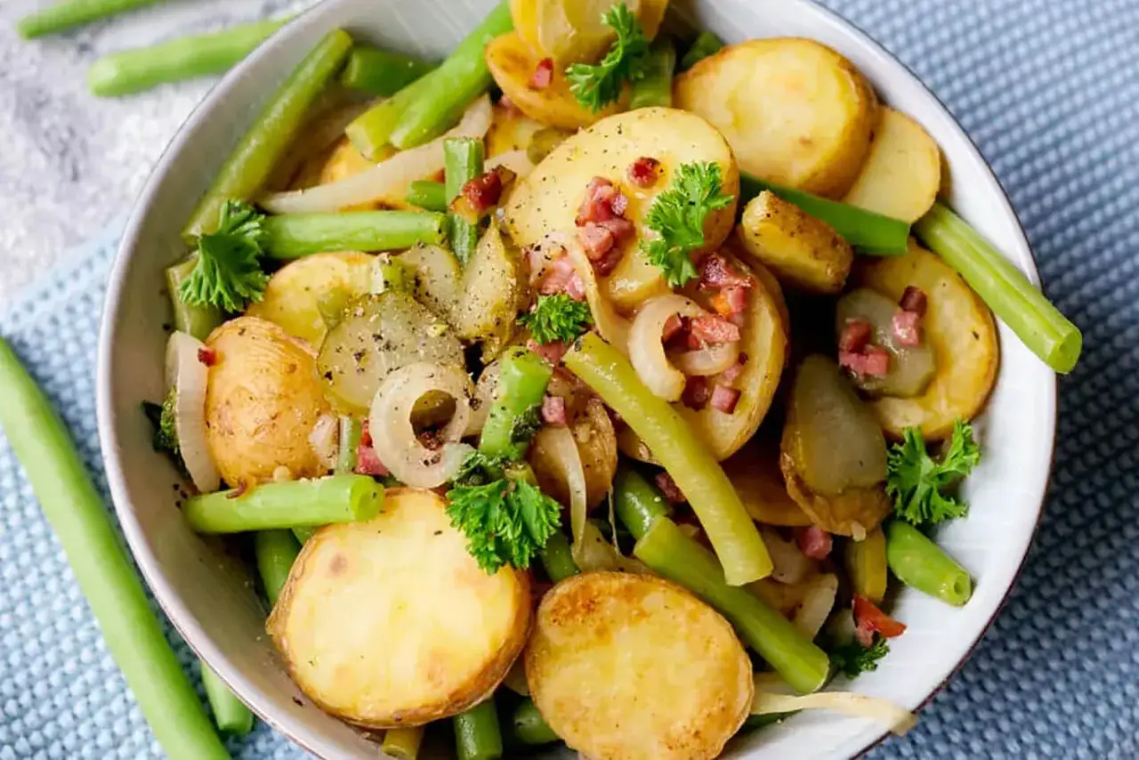 Herzhafter Kartoffelsalat mit gr&uuml;nen Bohnen, Speck und Zwiebeln. Eine festkochende Kartoffelsorte sorgt f&uuml;r Biss. Garniert mit Petersilie.