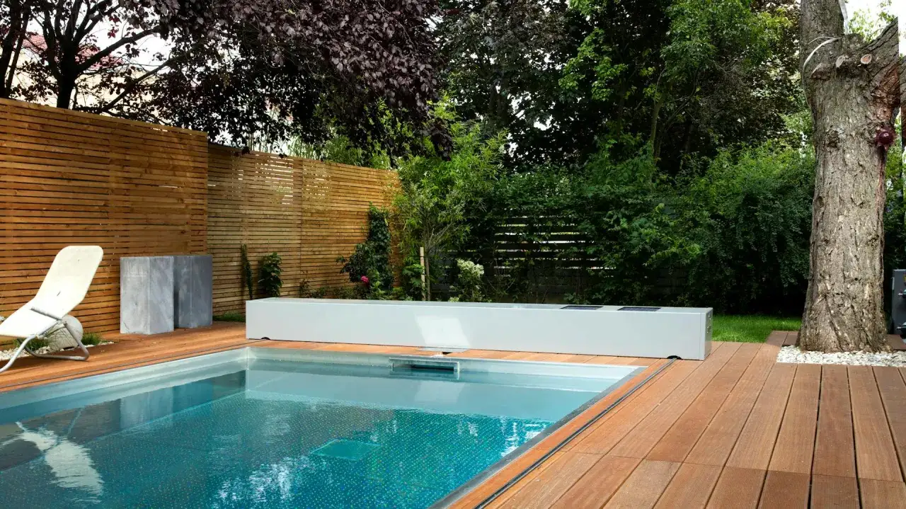 Moderne Gartenpool Ideen: Ein rechteckiger Pool mit Holzdeck, Liegestuhl und Sichtschutz aus Holzlamellen.